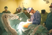 Začátek operace, příprava pracovních vstupů do hrudníku, robotické rameno v klidové poloze za zády pacienta.