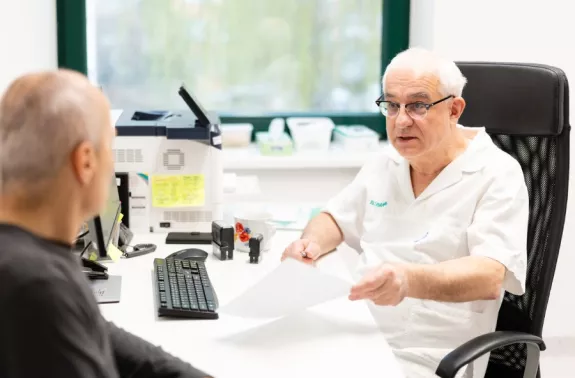 Lékař konzultuje výsledky screeningu ledvin s pacientem v rámci prevence chronického onemocnění ledvin. Fotografie z osvětové akce ke Světovému dni ledvin v nefrologické ambulanci B. Braun Avitum