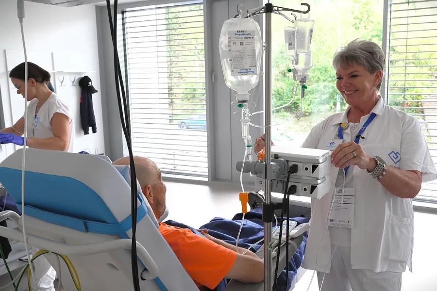 Jana Anna Kopecká, vrchní sestra Onkologické kliniky 2. LF UK a Fakultní nemocnice Motol a Homolka s pacientem Jiřím při bezpečném podávání chemoterapie